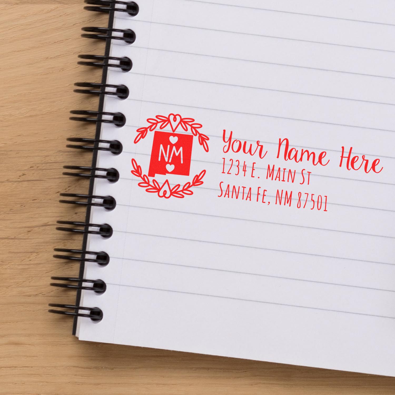 PSI Pre-Inked New Mexico State Customized Address Stamp in red ink on a notebook, featuring a decorative NM emblem and placeholder text for name and address in Santa Fe, NM.