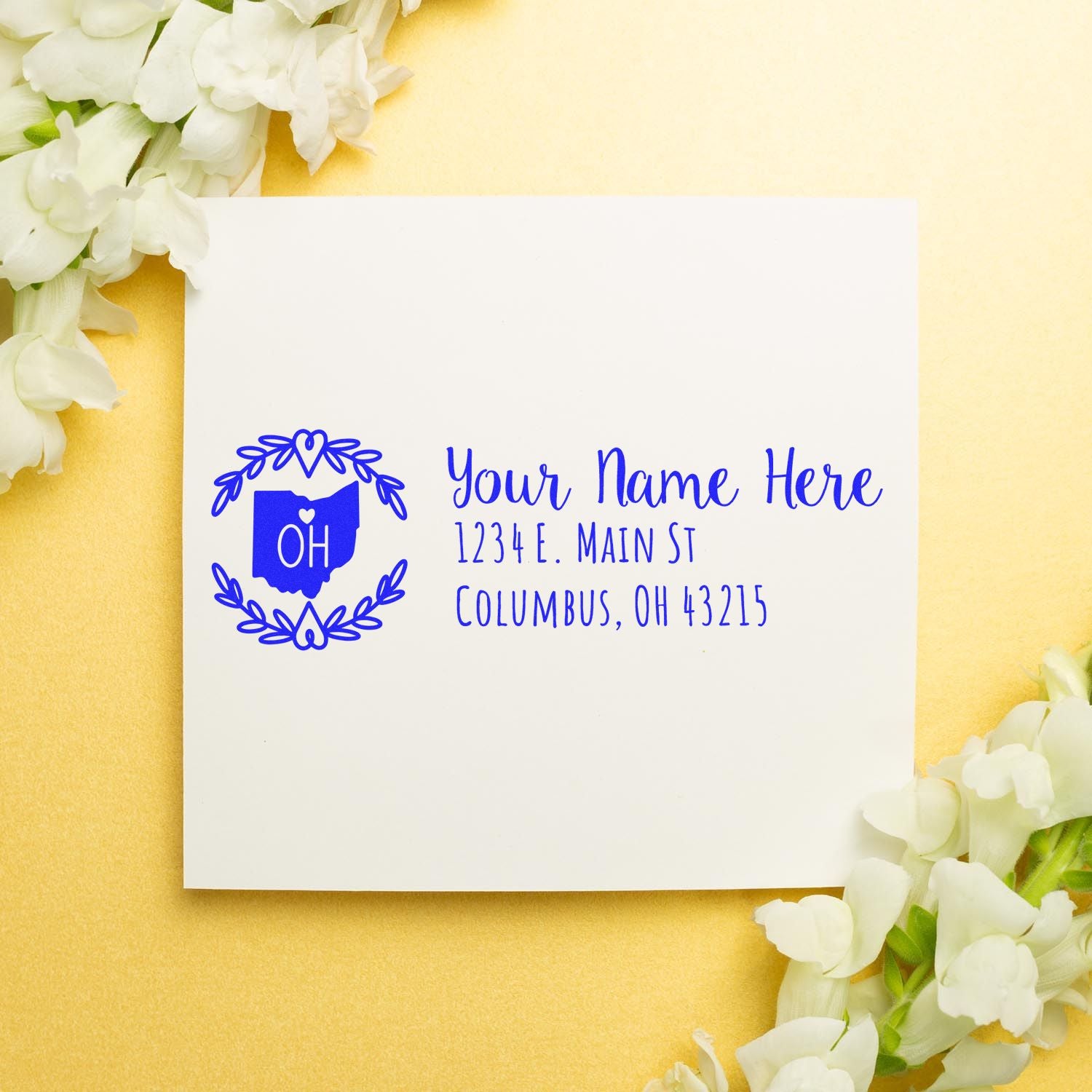 Ohio State Custom Return Address Stamp on a white envelope with blue text, surrounded by white flowers on a gold background.