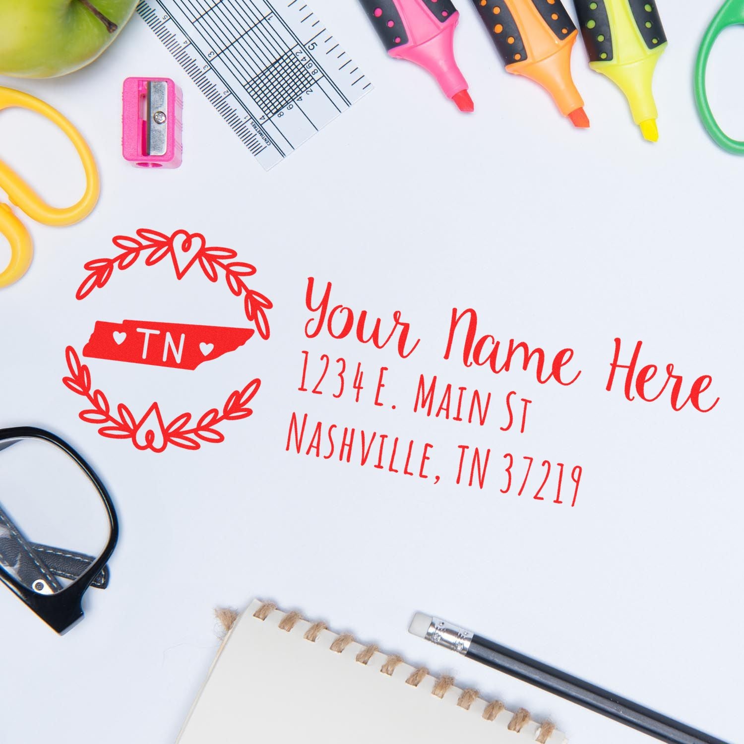 Tennessee State Custom Return Address Stamp in red ink on paper, surrounded by office supplies like highlighters, glasses, and a notebook.