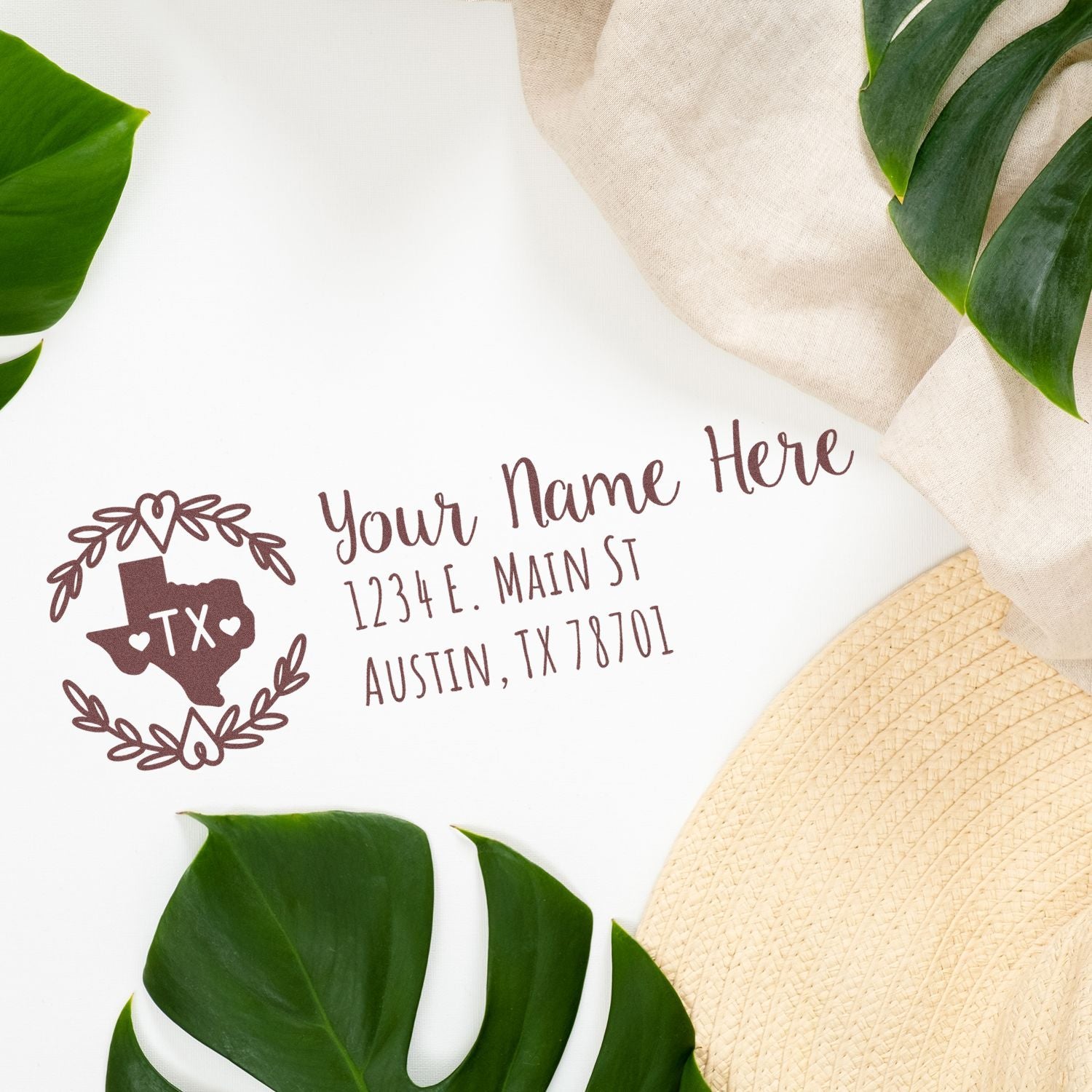 Texas State Custom Return Address Stamp on white paper with a decorative Texas outline and address text. Surrounded by green leaves and a beige hat, creating a stylish and personalized stationery look.