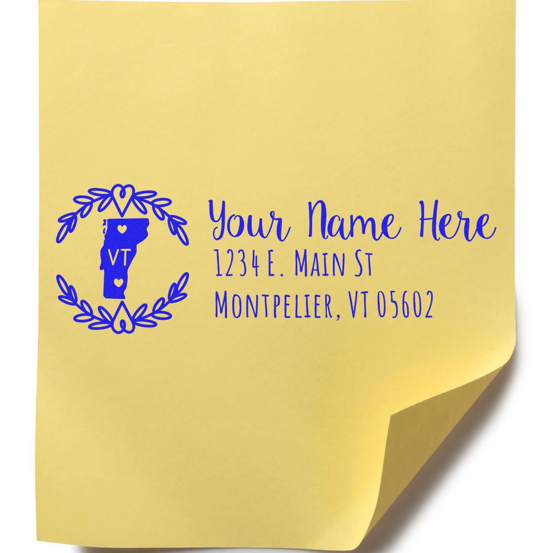 Yellow sticky note with blue ink impression of the Self-Inking State Wreath of Vermont Address Stamp, featuring a Vermont outline, hearts, and space for a name and address.