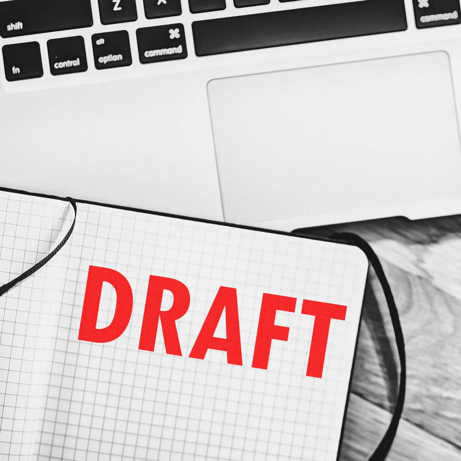 Large Pre-Inked Draft Stamp in red ink on a notebook page, placed next to a laptop keyboard.