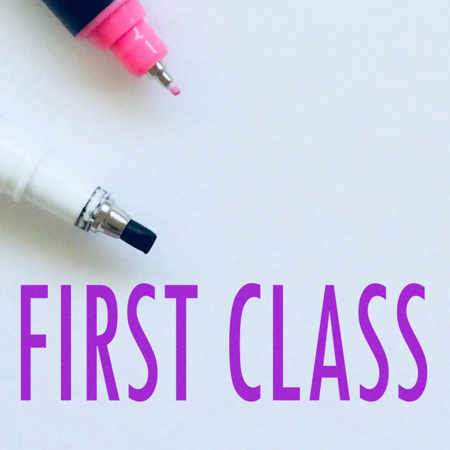 Image of a Large Pre-Inked First Class Stamp with the words FIRST CLASS in purple, alongside two marker tips, one pink and one black.