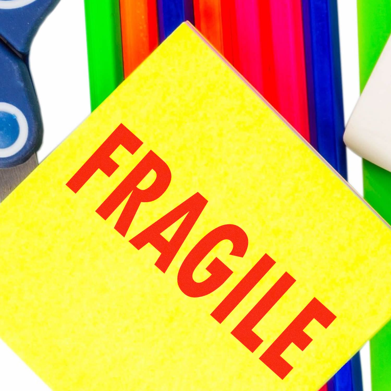 Large Pre-Inked Fragile Stamp with bold red FRAGILE text on a yellow background, surrounded by colorful office supplies.