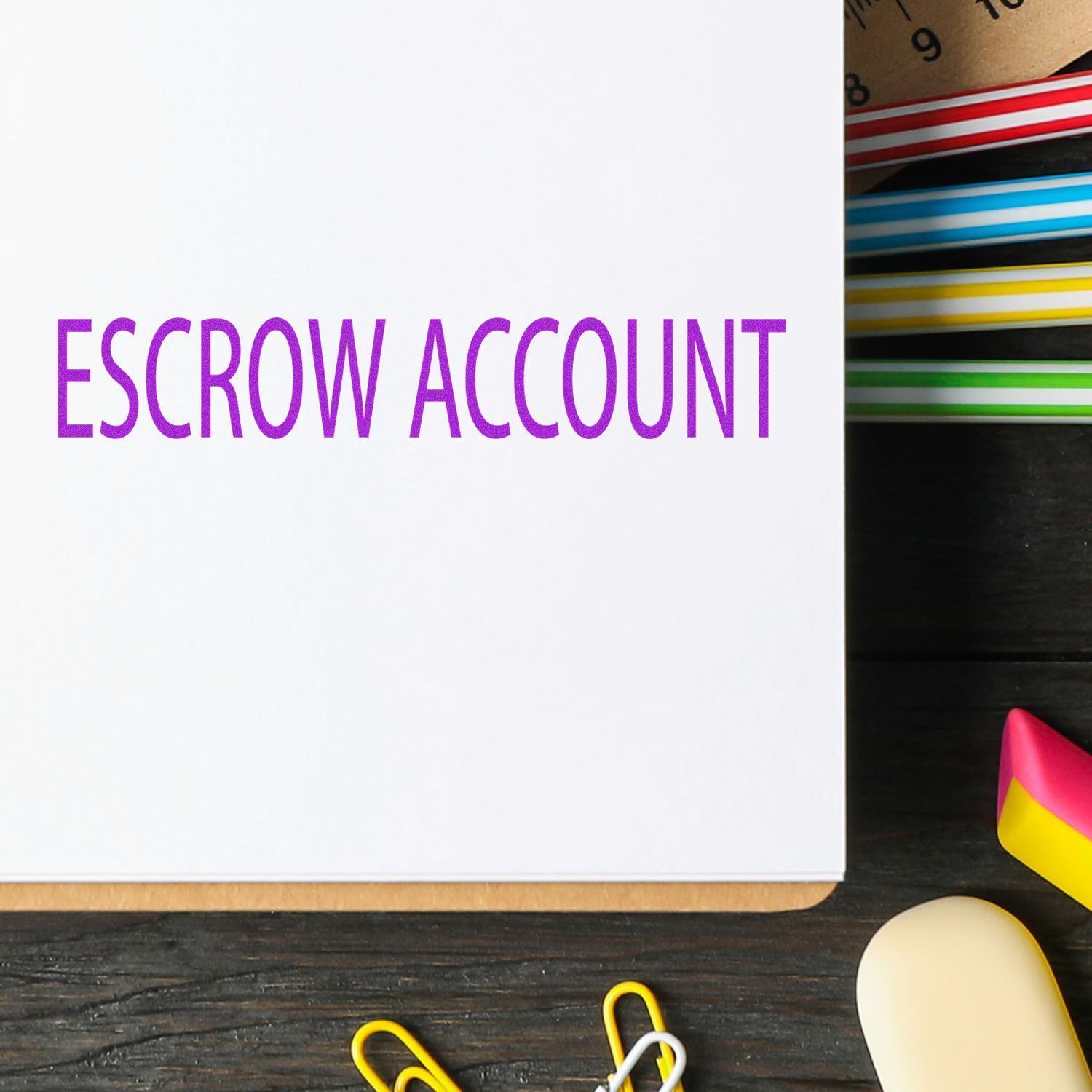 Large Pre-Inked Escrow Account Stamp in purple ink on white paper, with colorful stationery items in the background on a wooden desk.