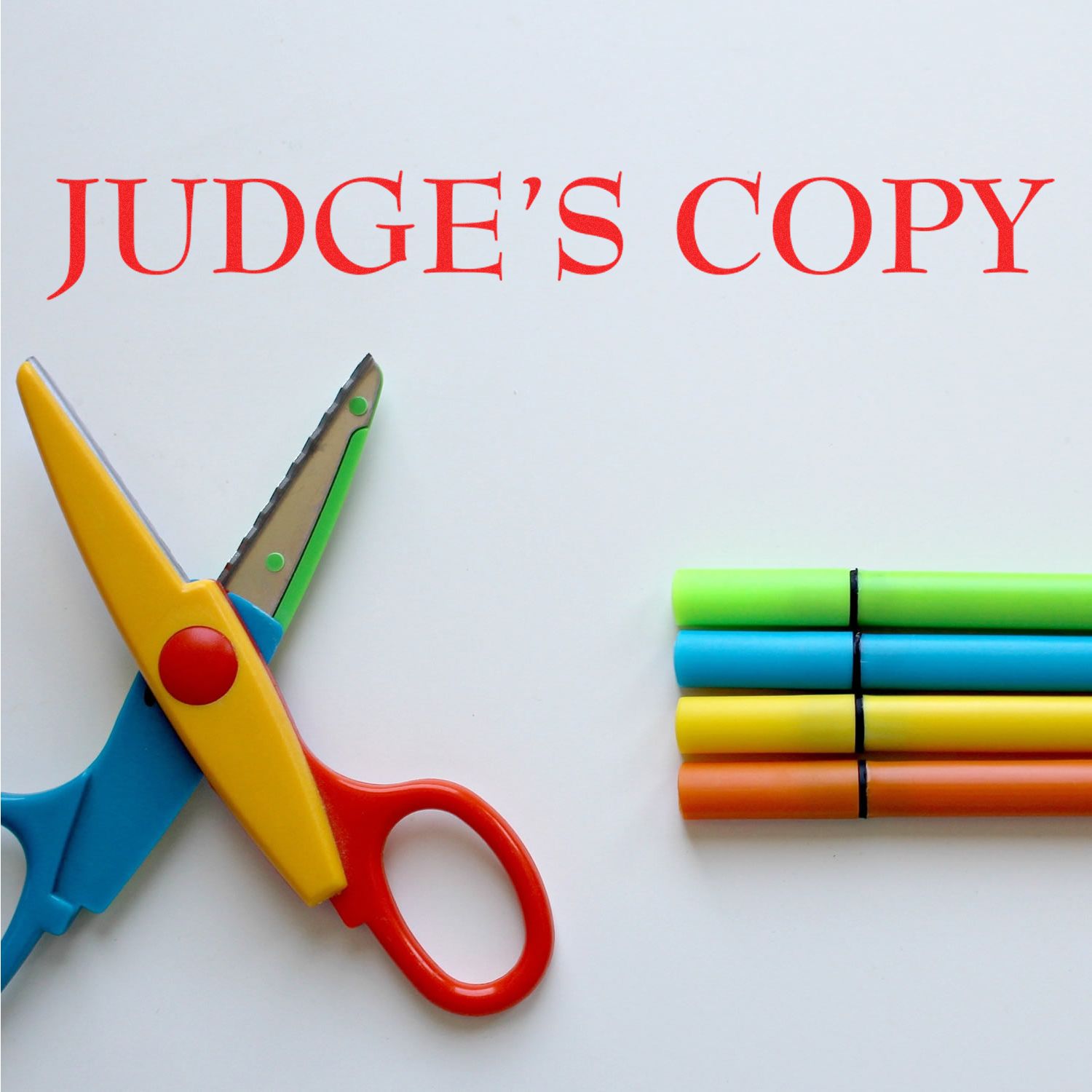 Large Pre-Inked Judge's Copy Stamp in red ink on white paper, with colorful scissors and markers beside it.