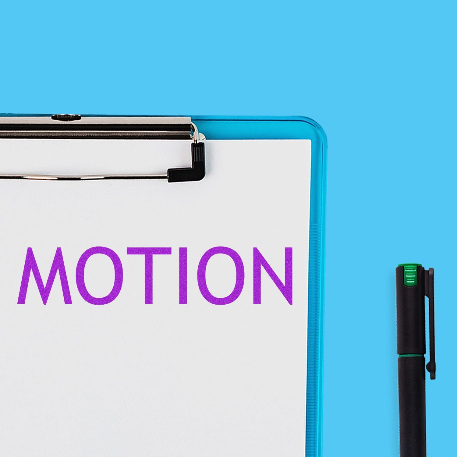 Large Pre-Inked Motion Stamp imprinting the word MOTION in purple on a white sheet clipped to a blue clipboard, with a black pen nearby.