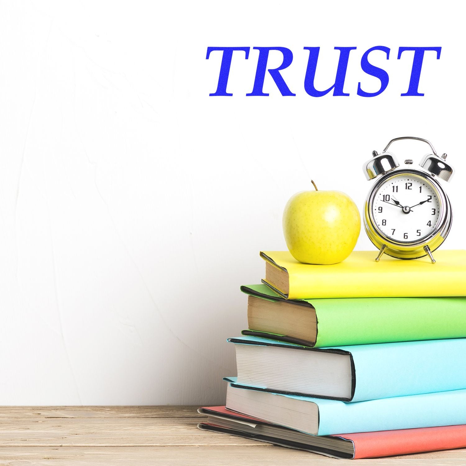 A stack of colorful books with an apple and clock on top, with the word TRUST above. Large Pre-Inked Trust Stamp.