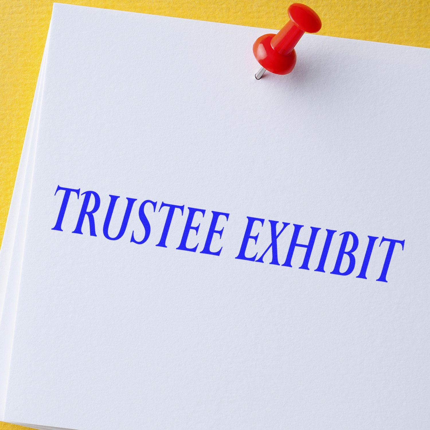 Large Pre-Inked Trustee Exhibit Stamp imprint on white paper with a red pushpin on a yellow background.