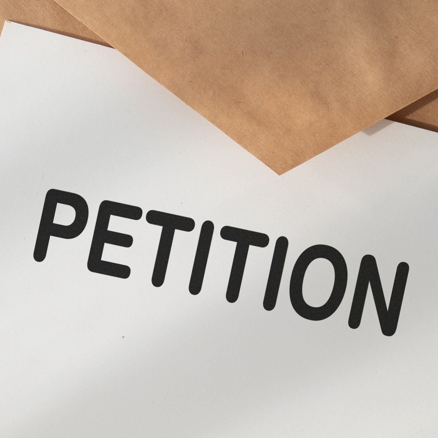 Large Pre-Inked Petition Stamp imprint on white paper with brown envelopes in the background.