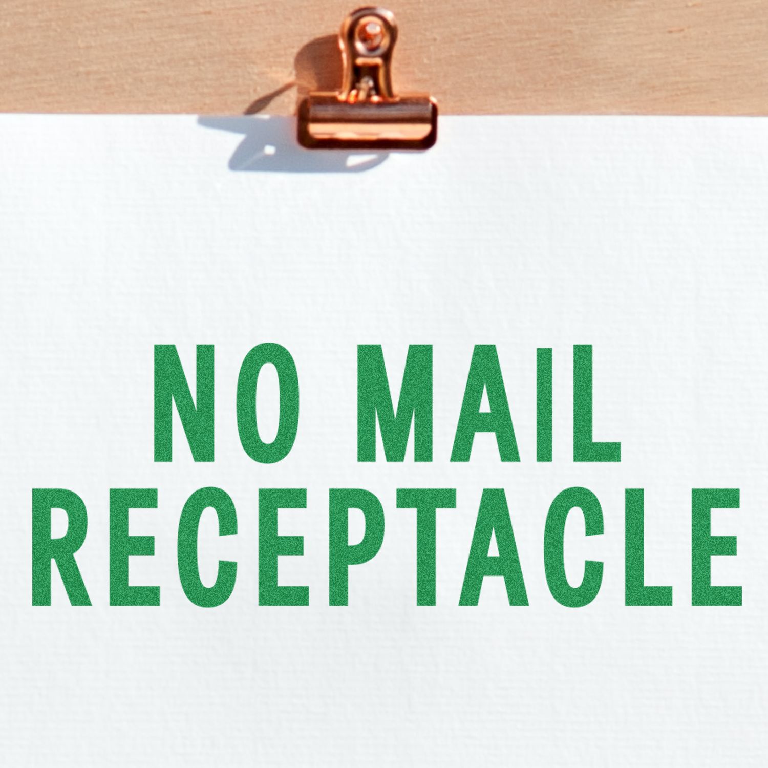 Large Pre-Inked No Mail Receptacle Stamp with green text on white paper, clipped to a wooden board.