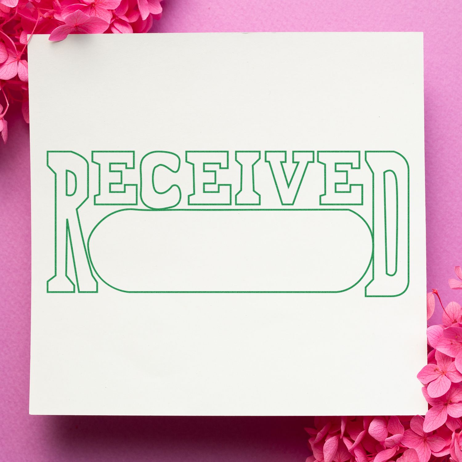 Large Pre-Inked Received with Date Box Stamp on white paper with pink flowers on a pink background.