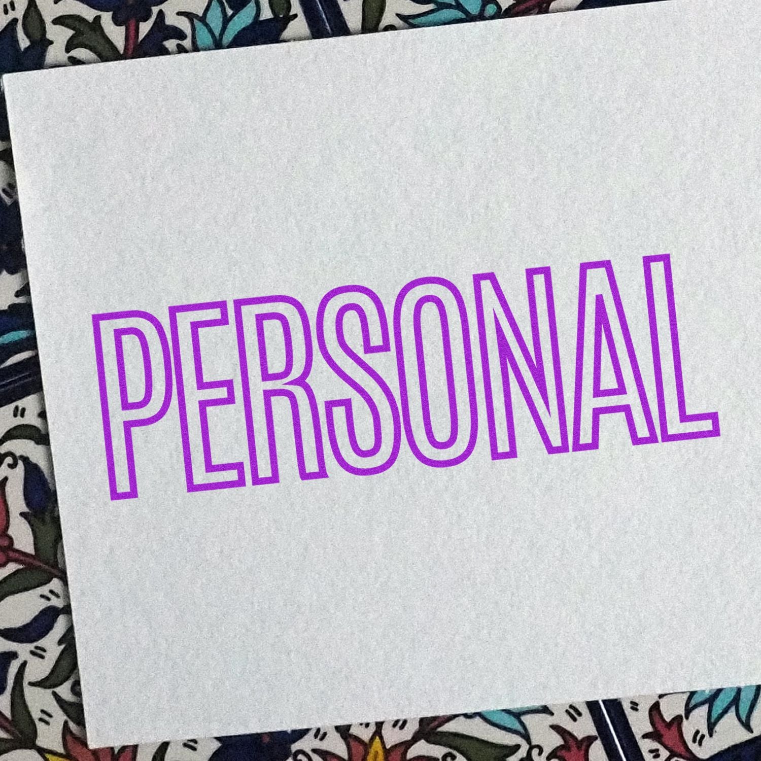 Large Pre-Inked Outline Personal Stamp imprinting the word 'PERSONAL' in bold purple outline on a white card with a floral background.