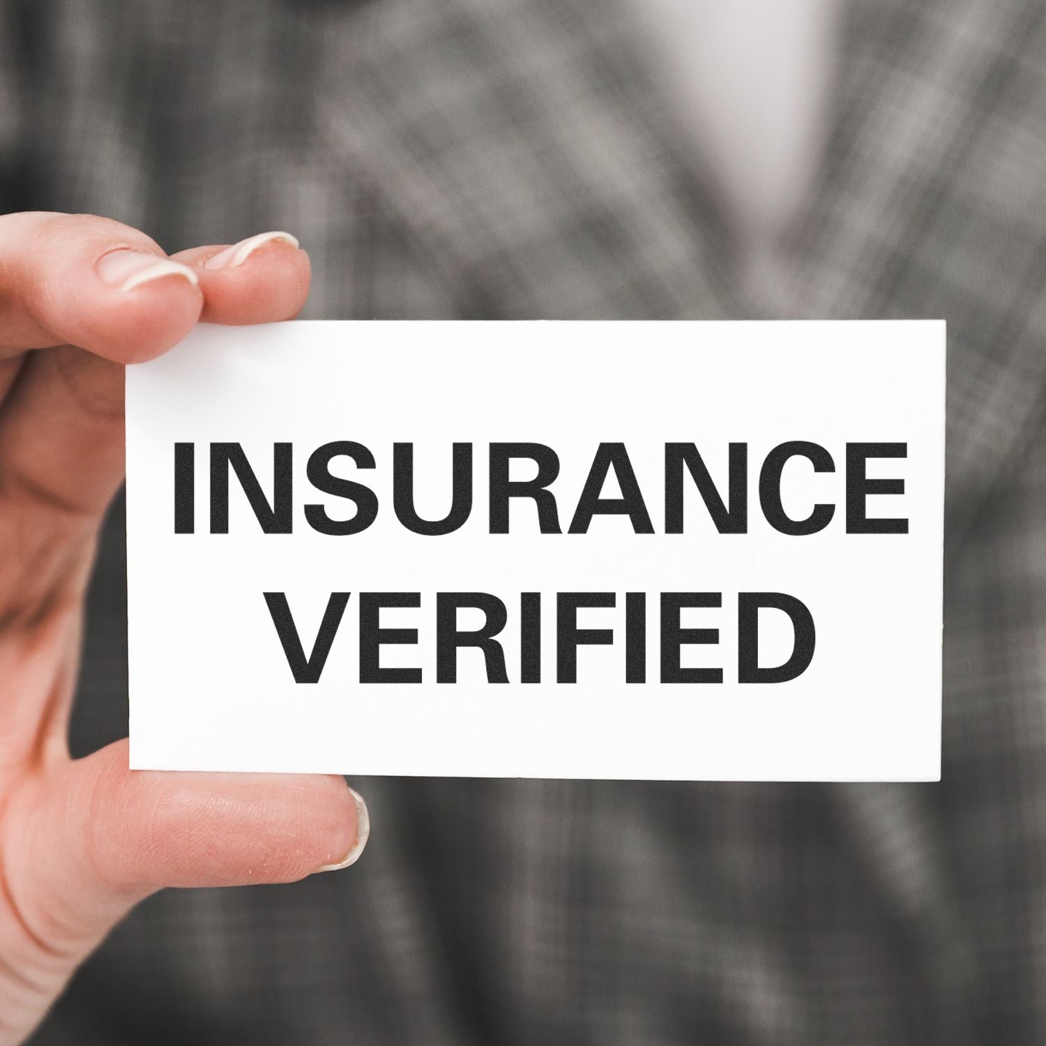 Person holding a card stamped with INSURANCE VERIFIED using the Large Pre-Inked Insurance Verified Stamp, against a blurred background.