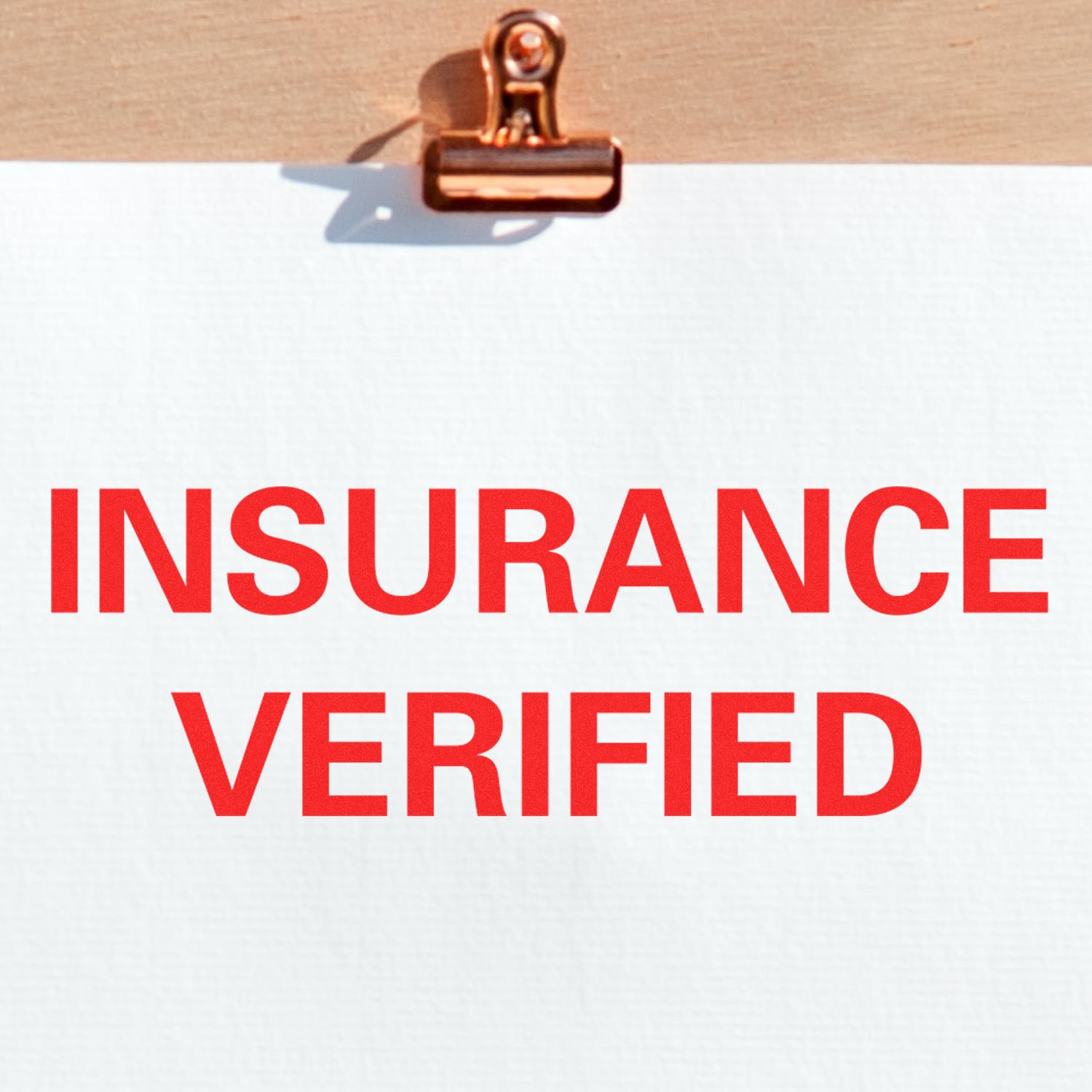 Large Pre-Inked Insurance Verified Stamp in red ink on white paper, clipped to a wooden board.