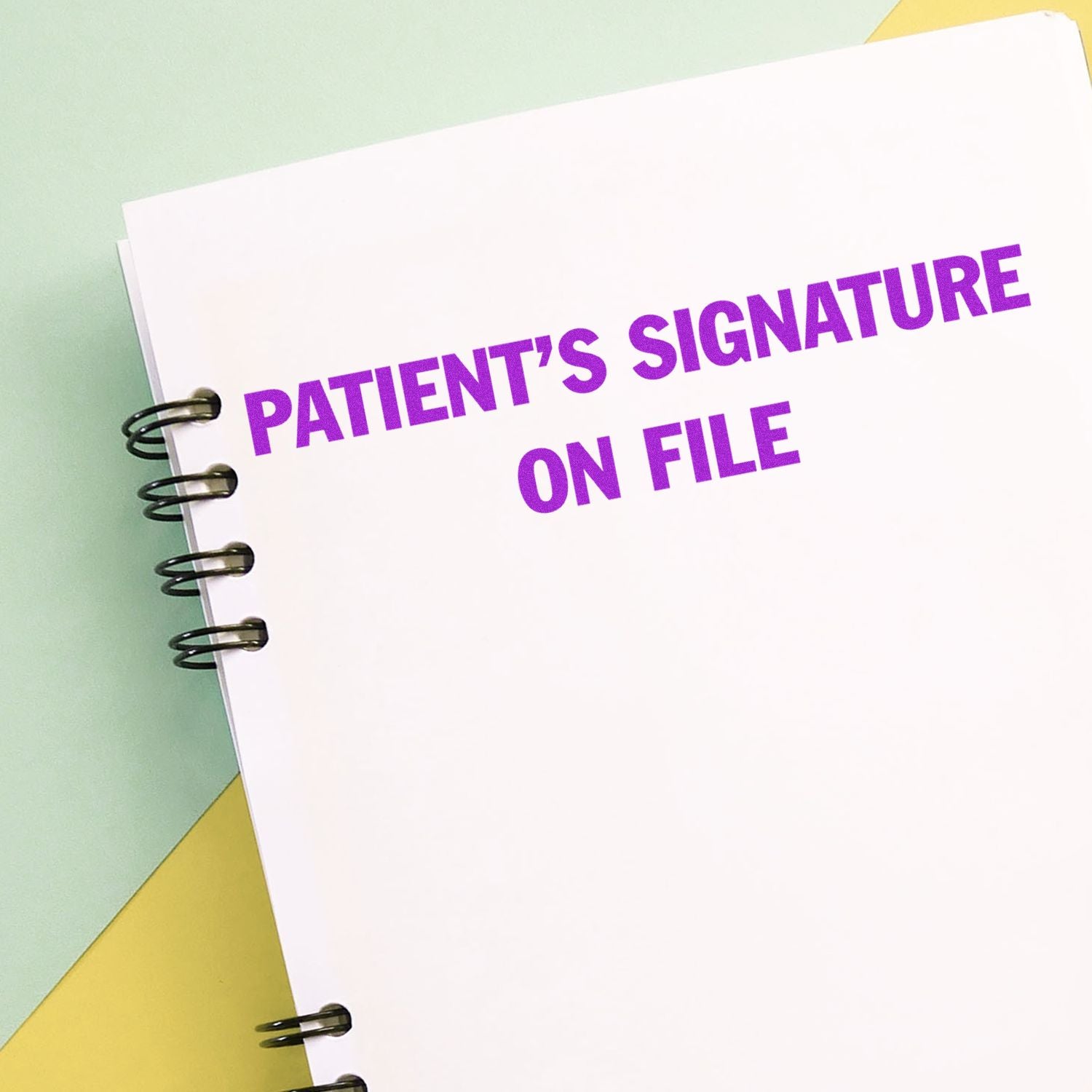 Large Pre-Inked Patient's Signature on File Stamp in purple ink on a spiral-bound notebook with a pastel background.