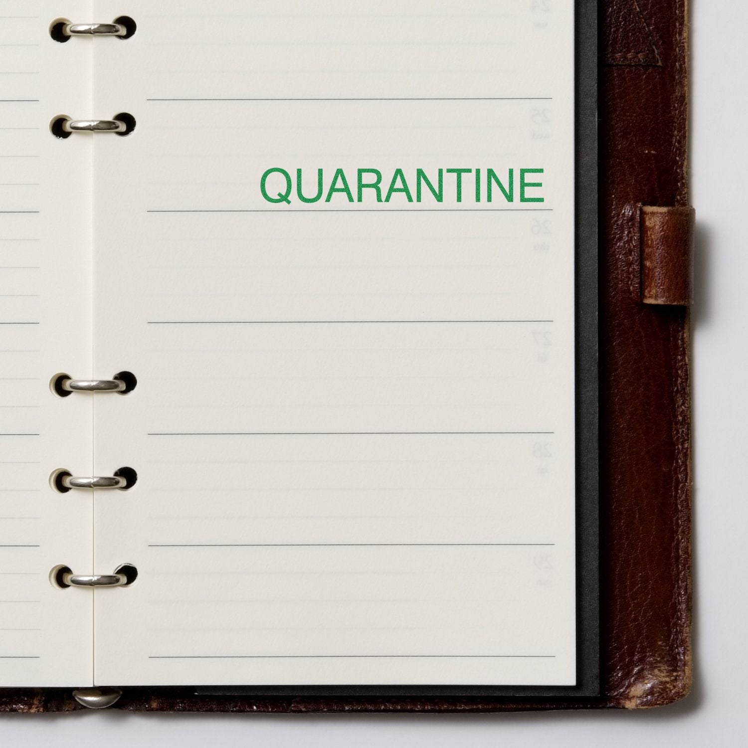 Open notebook with QUARANTINE stamped in green ink using the Large Self Inking Quarantine Stamp.