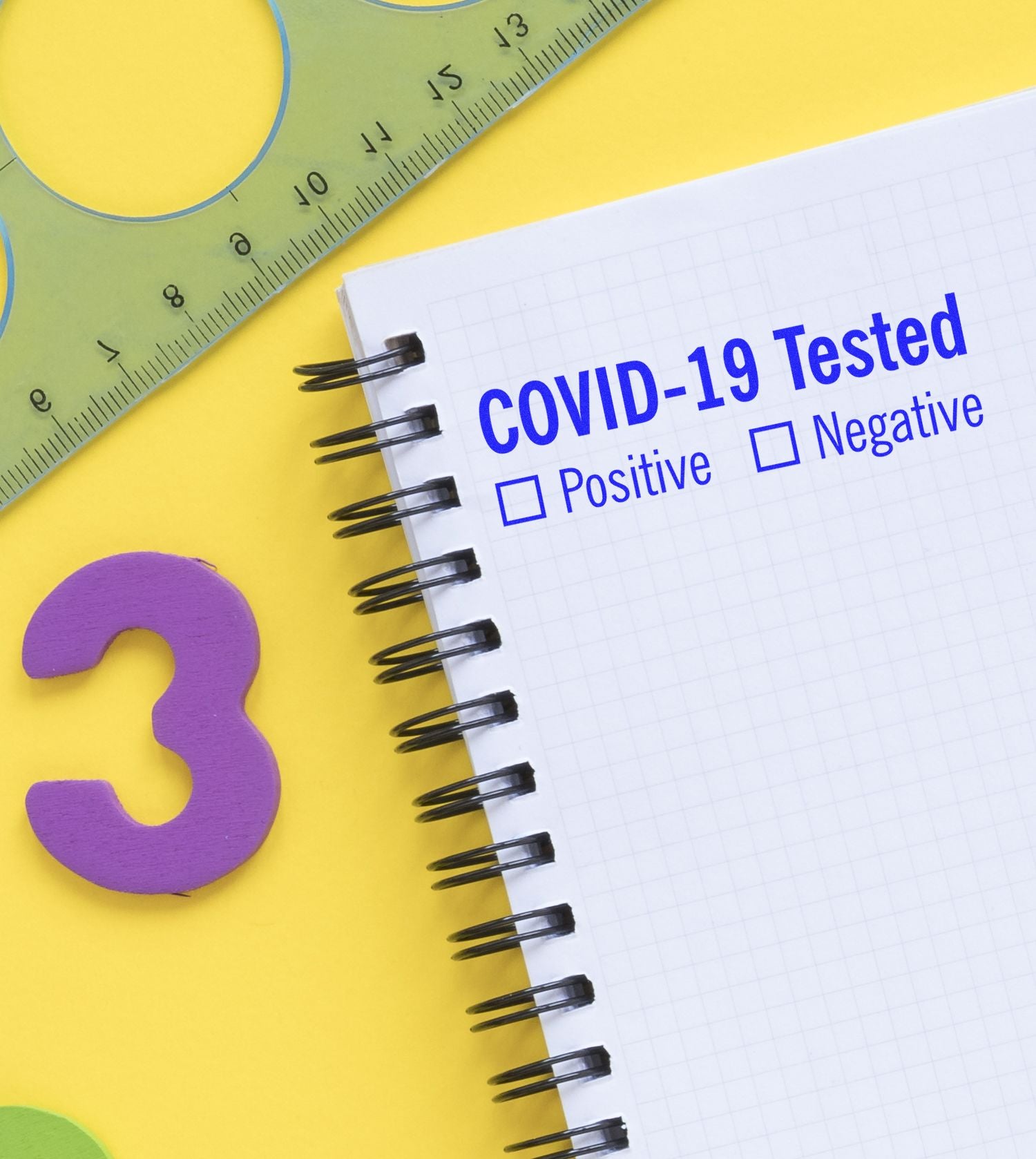 Notebook with COVID-19 Tested stamped using Large Self Inking Covid-19 Tested Stamp, surrounded by a ruler, stencil, and a purple number 3.