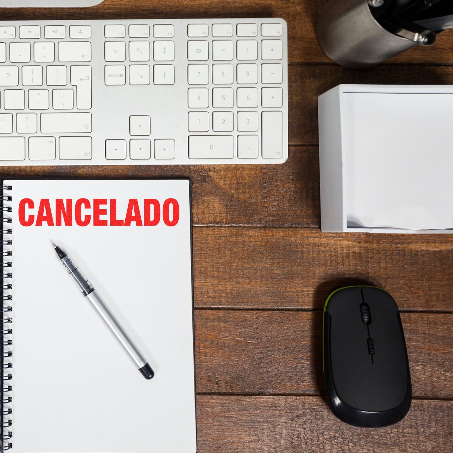 Large Self Inking Cancelado Stamp used on a notebook, placed on a wooden desk with a keyboard, mouse, pen, and other office supplies.