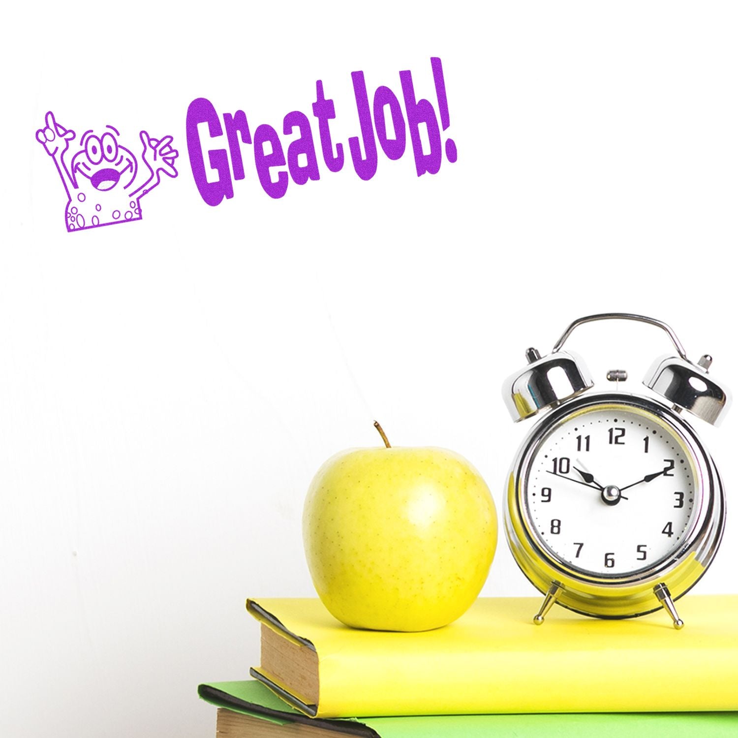 Large Pre-Inked Great Job Stamp in purple ink on white background, next to a stack of books, a green apple, and an alarm clock.