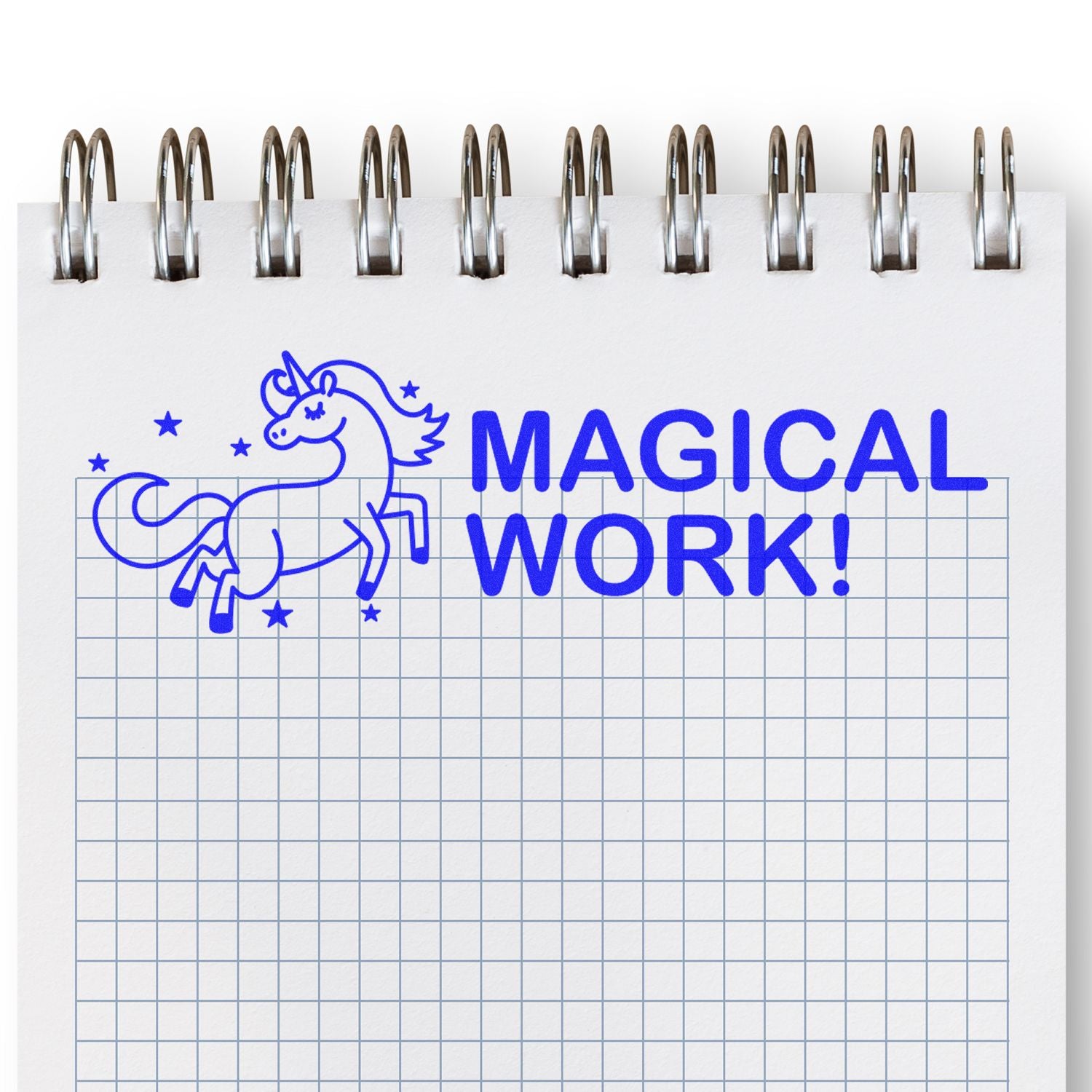 A notebook page stamped with a blue unicorn and stars, and the text MAGICAL WORK! using the Large Pre-Inked Magical Work Stamp.