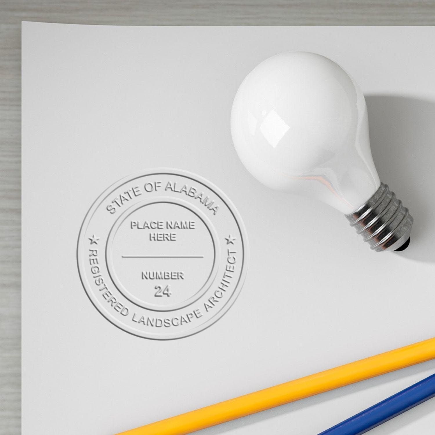 An in use photo of the Gift Alabama Landscape Architect Seal showing a sample imprint on a cardstock