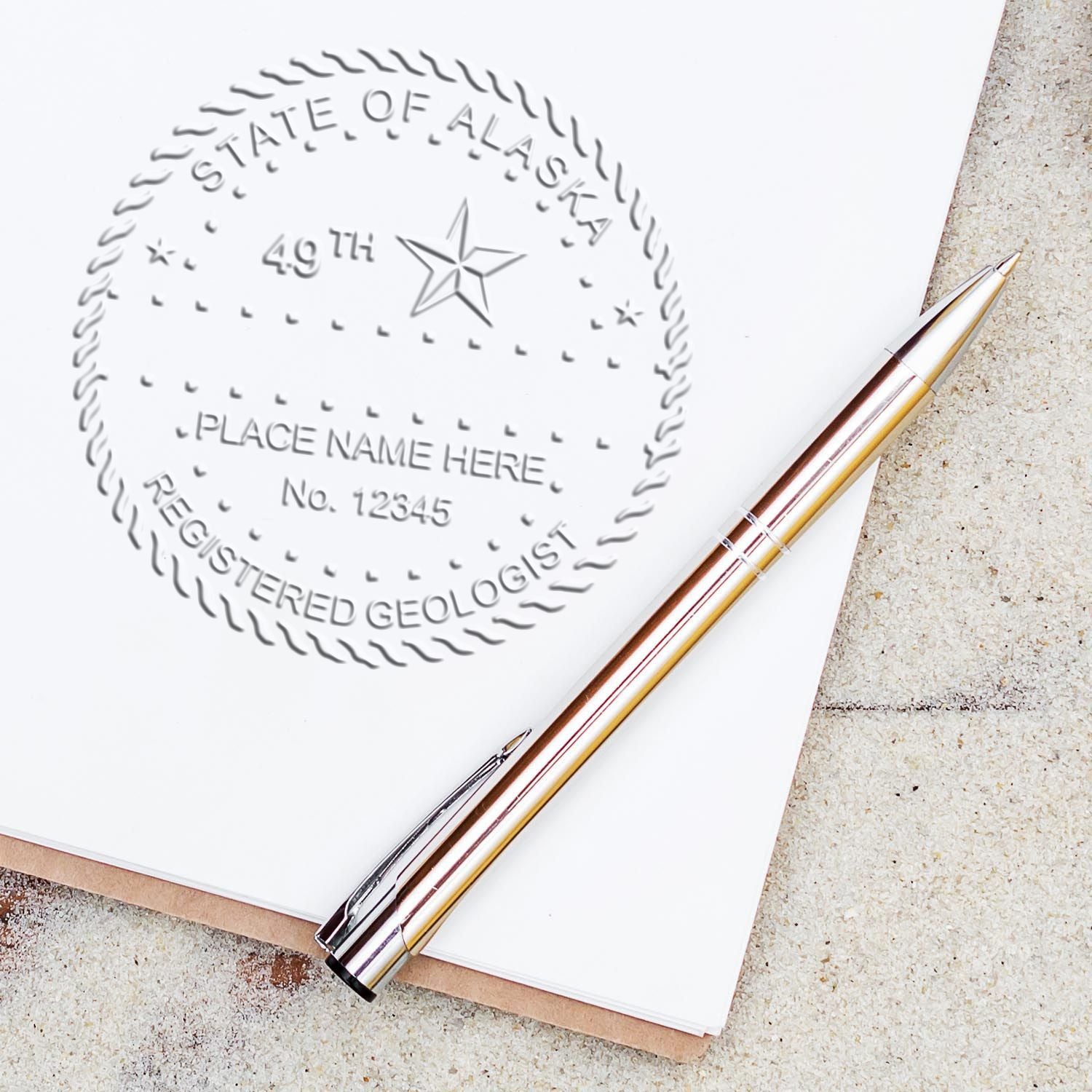 An in use photo of the Long Reach Alaska Geology Seal showing a sample imprint on a cardstock