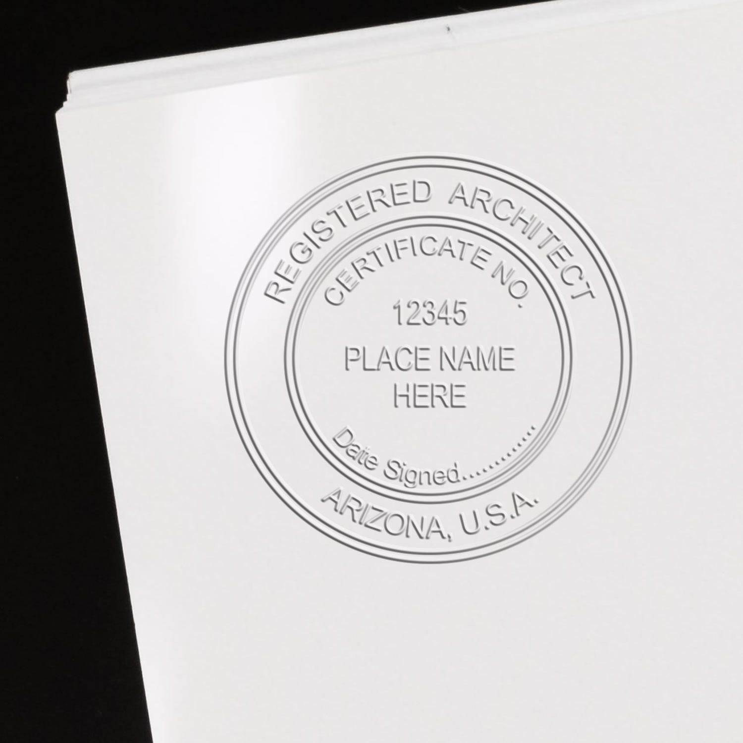 A lifestyle photo showing a stamped image of the Handheld Arizona Architect Seal Embosser on a piece of paper