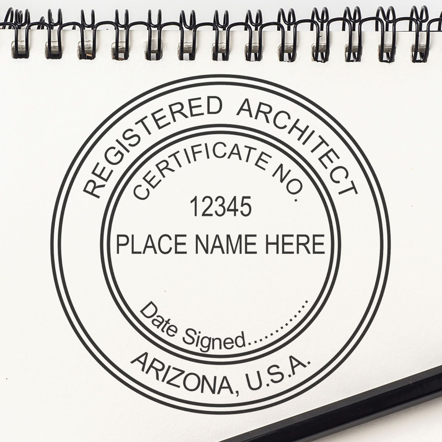 Arizona Architect Seal Stamp on a spiral-bound notebook, displaying Registered Architect, Certificate No., Place Name Here, Date Signed, Arizona, U.S.A.