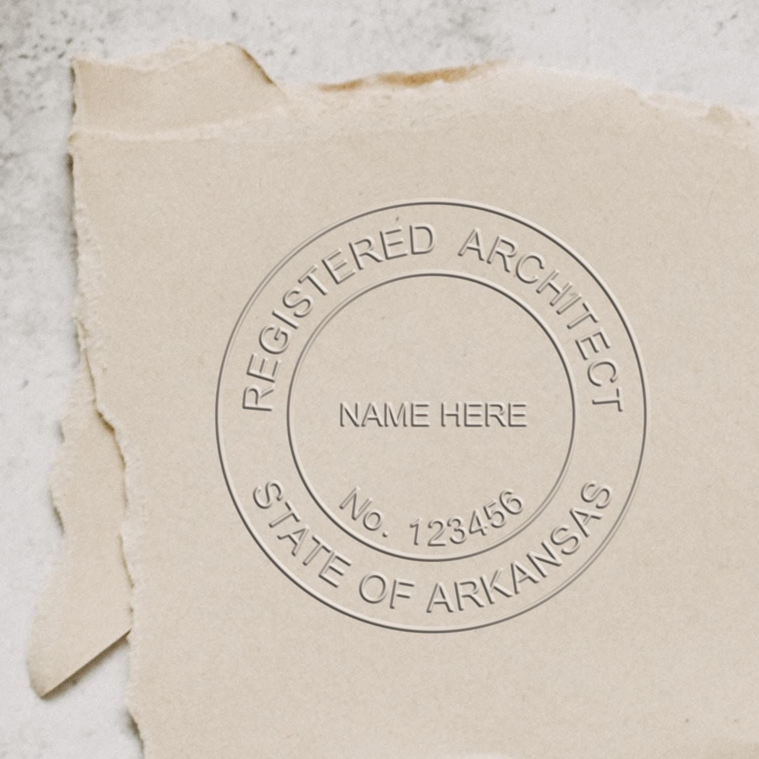 An in use photo of the Hybrid Arkansas Architect Seal showing a sample imprint on a cardstock