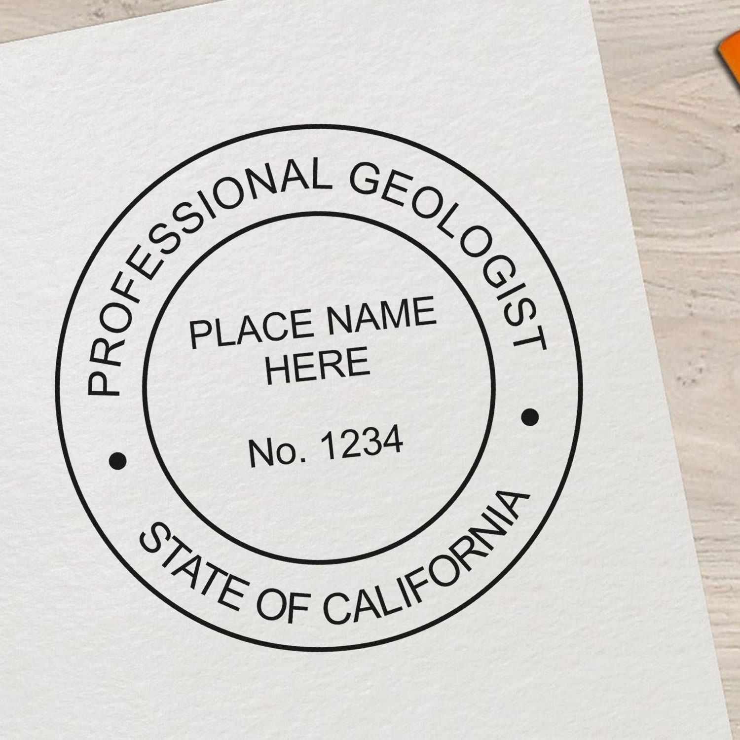 An in use photo of the Self-Inking California Geologist Stamp showing a sample imprint on a cardstock