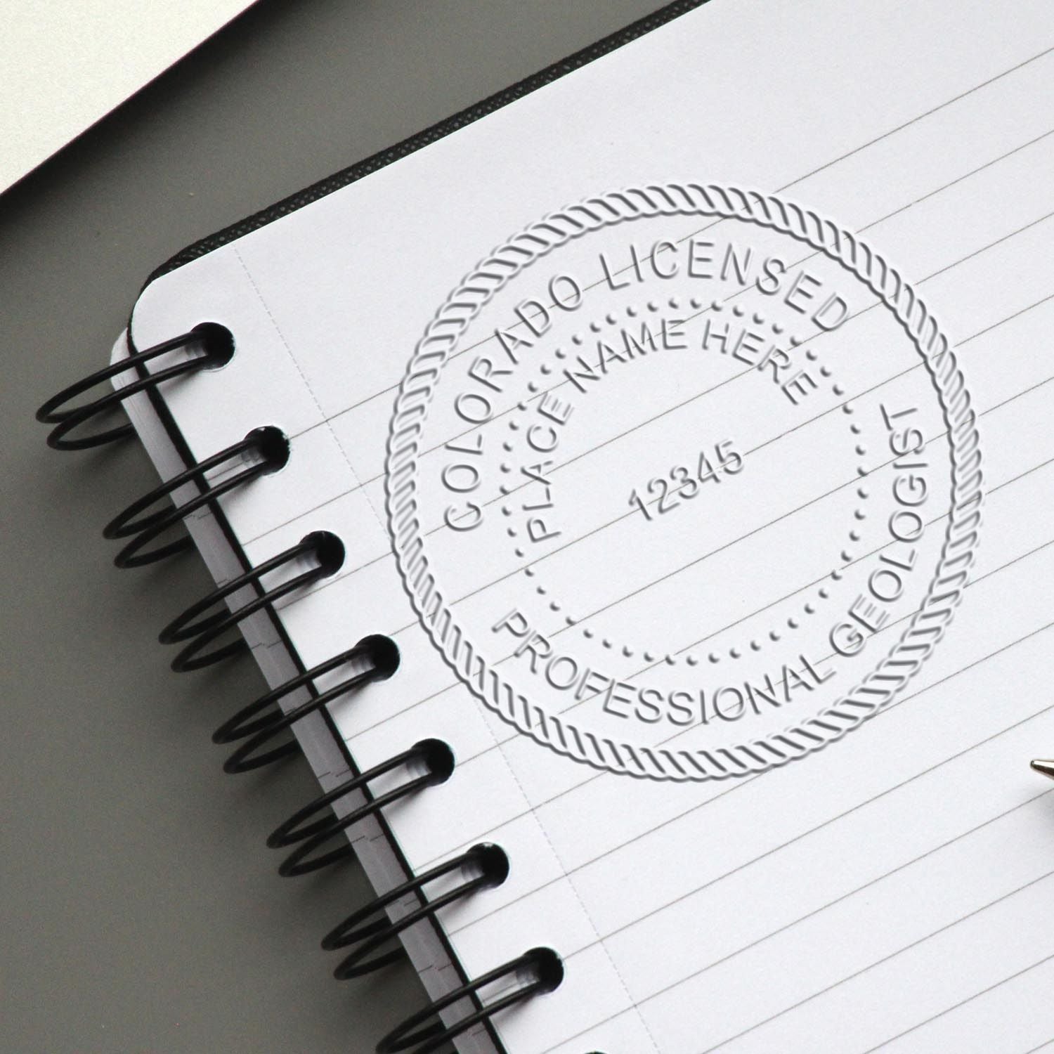 An in use photo of the Colorado Geologist Desk Seal showing a sample imprint on a cardstock