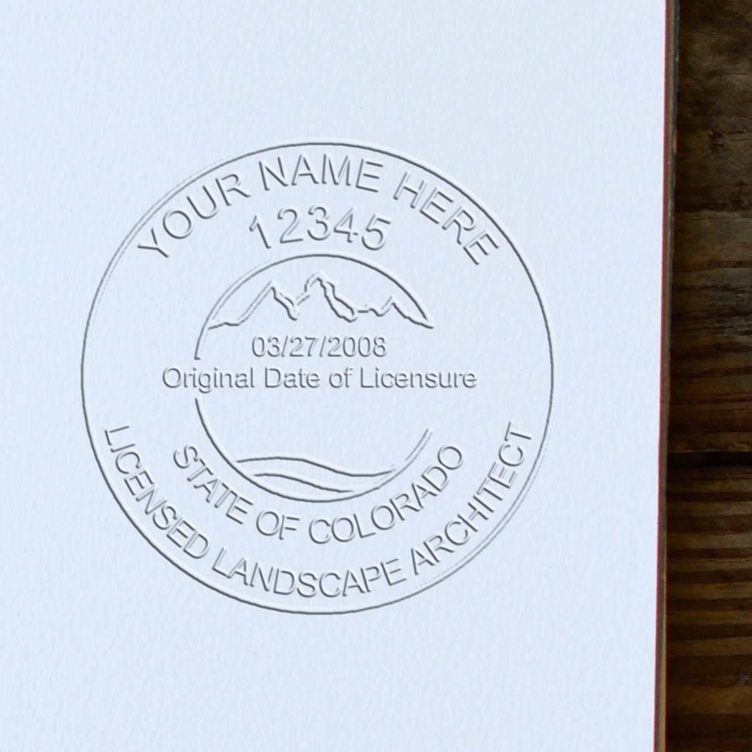 A photograph of the State of Colorado Handheld Landscape Architect Seal stamp impression reveals a vivid, professional image of the on paper.