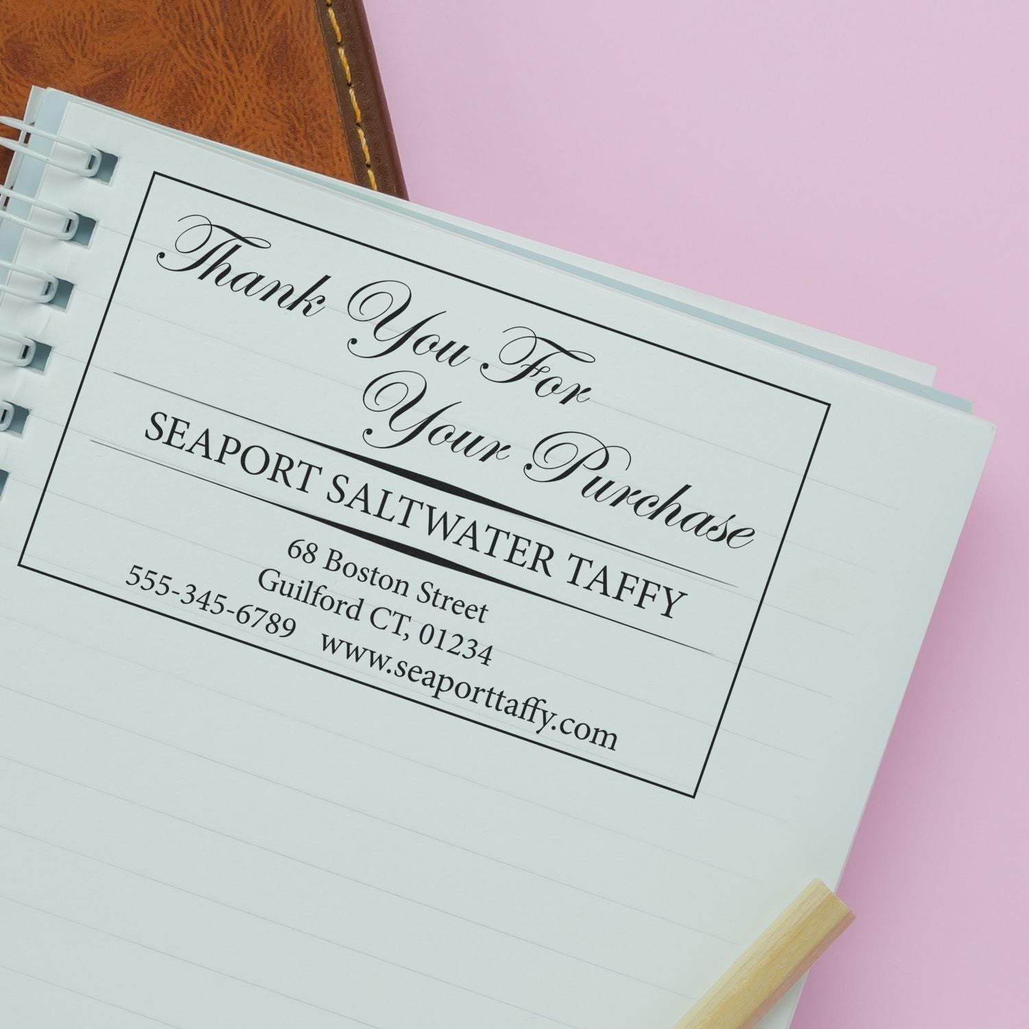 Custom Self Inking Stamp Trodat 5208 Size 2 x 2-3/4 used on a notebook page, displaying a thank you message from Seaport Saltwater Taffy.