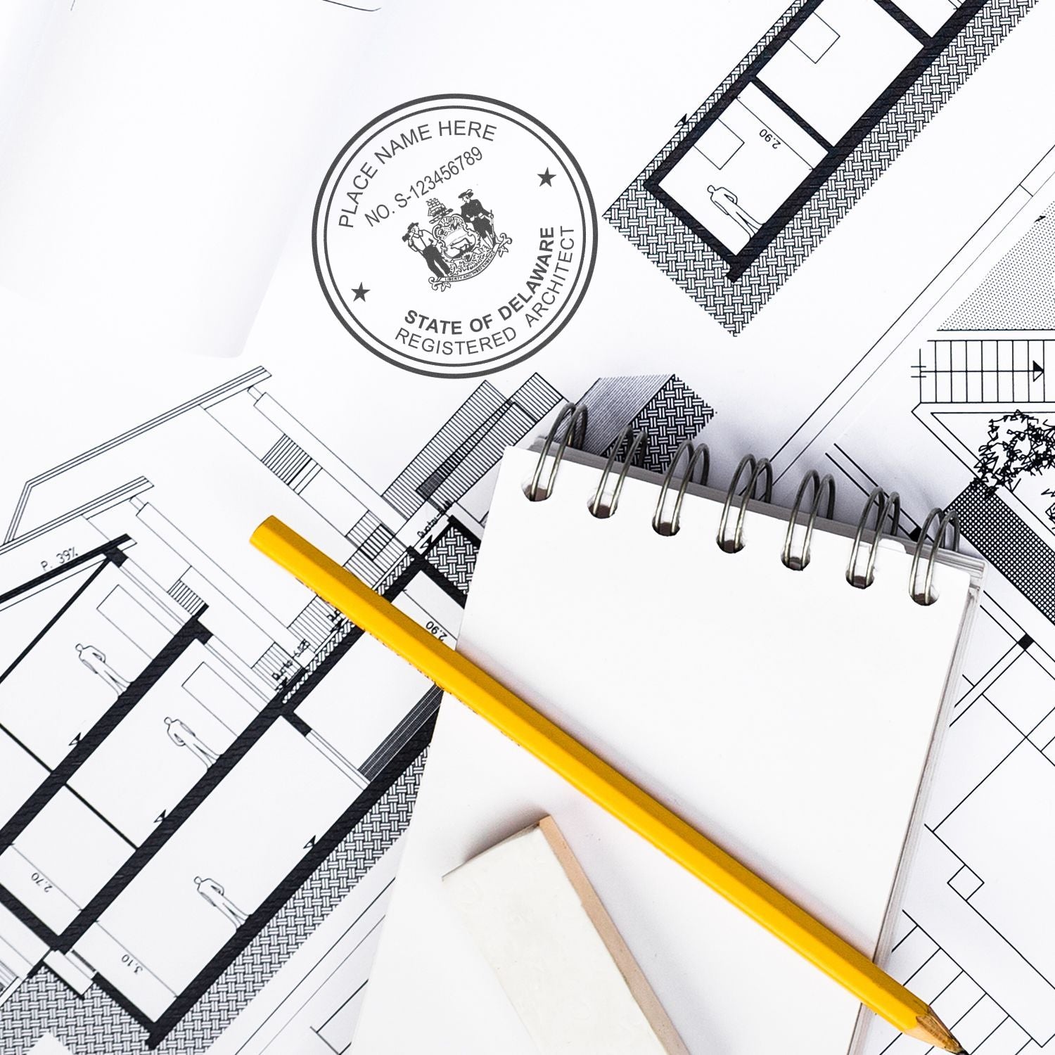 Digital Delaware Architect Stamp, Electronic Seal for Delaware Architect on architectural blueprints with a notebook, pencil, and eraser.