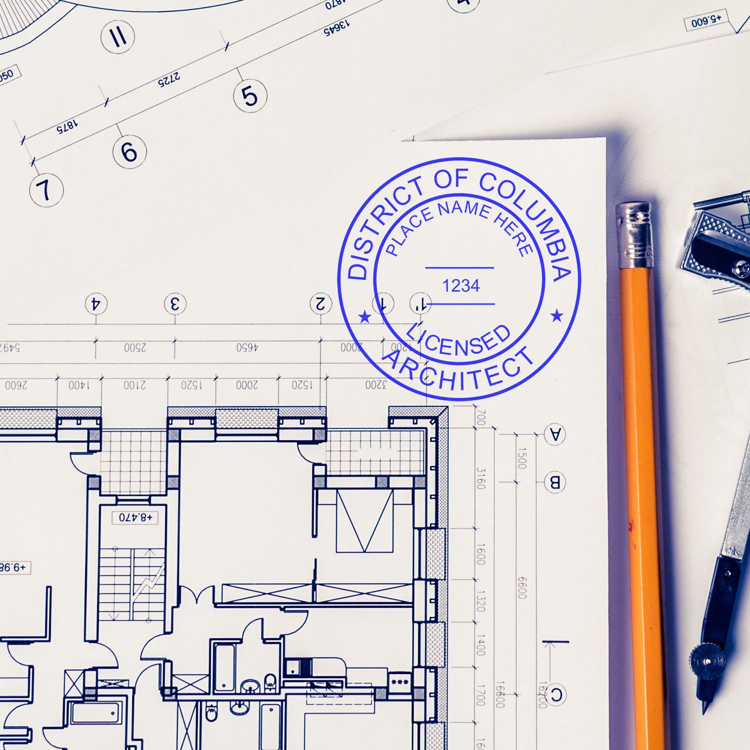 Self Inking District of Columbia Architect Stamp on architectural blueprint with pencil and drafting tools nearby.