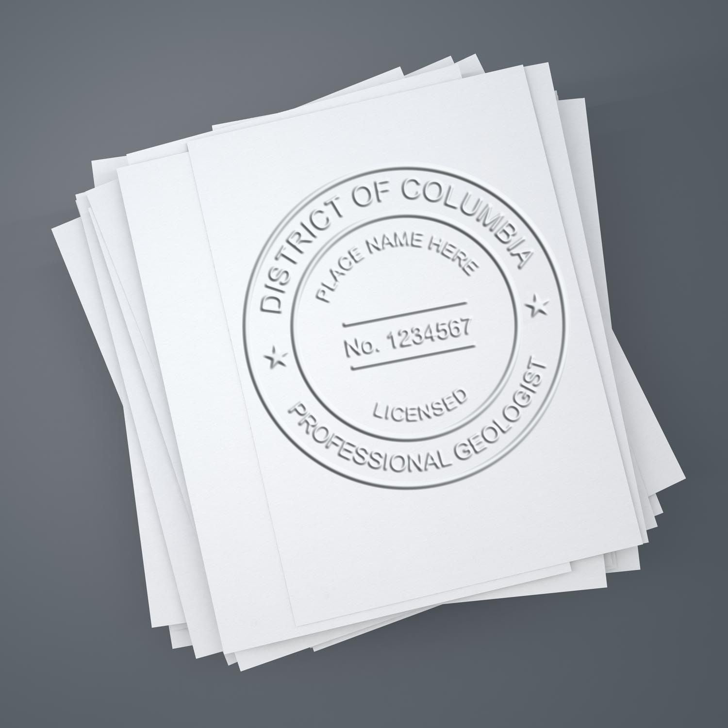 A lifestyle photo showing a stamped image of the Heavy Duty Cast Iron District of Columbia Geologist Seal Embosser on a piece of paper
