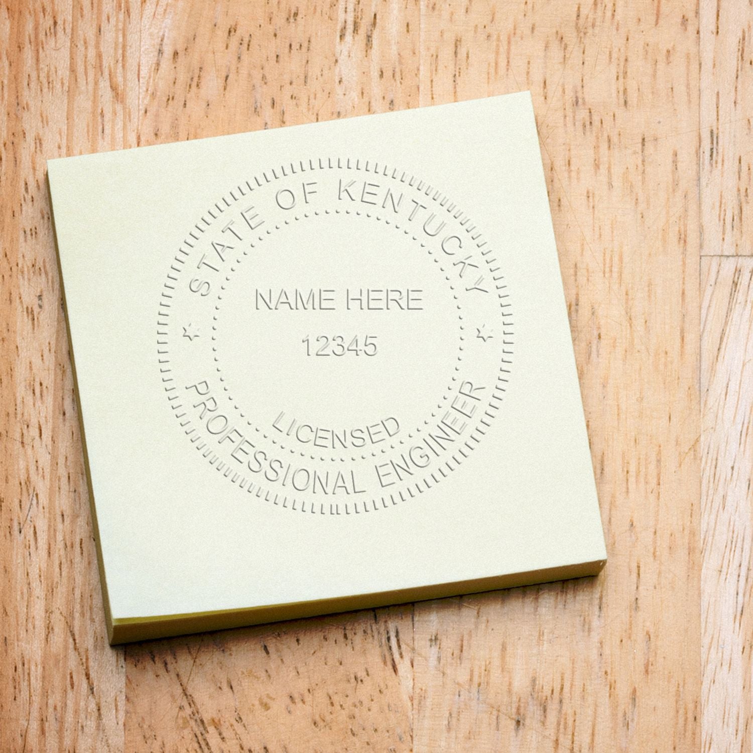 A Professional Engineer Desk Seal Embosser imprint on a yellow sticky note, displaying 'State of Kentucky, Licensed Professional Engineer' with space for name and license number.