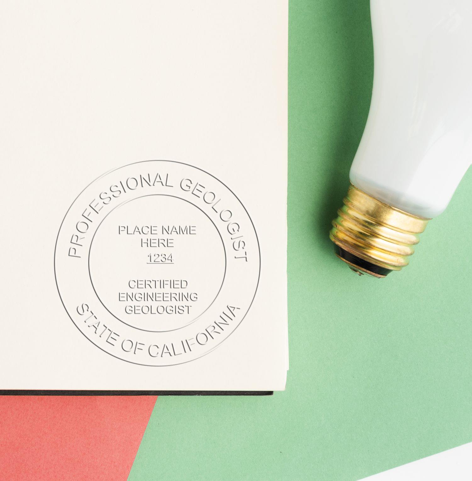 The Engineering Geologist Pink Gift Embosser is shown in use, creating a professional seal on a document. The seal reads 'Professional Geologist, State of California, Certified Engineering Geologist.'