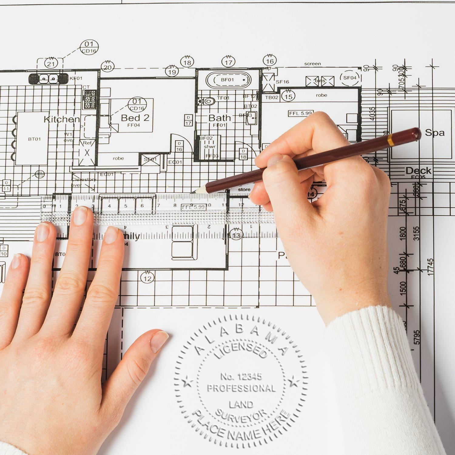 Person using the Land Surveyor Extended Long Reach Desk Seal Embosser on architectural plans with a pen in hand.