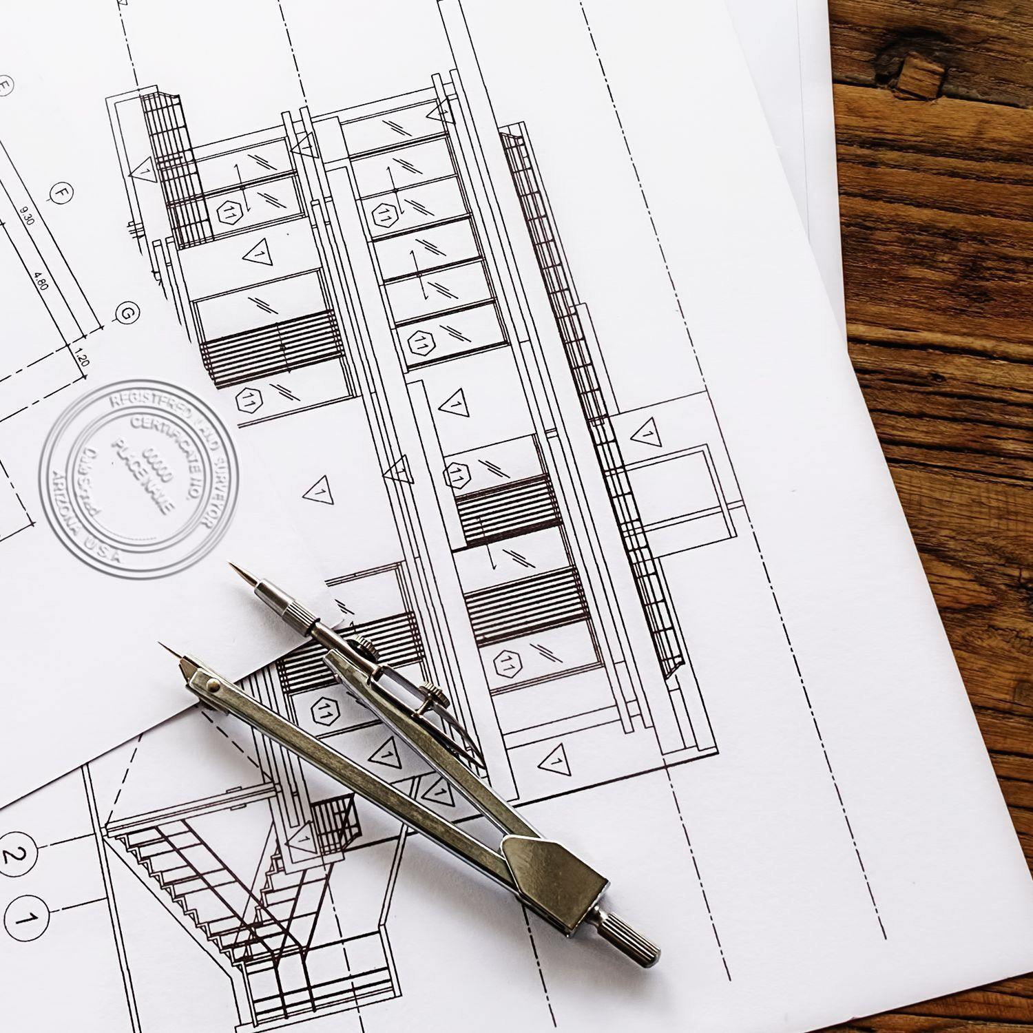 Land Surveyor Extended Long Reach Desk Seal Embosser in use on architectural blueprints, with a compass tool placed on the plans.