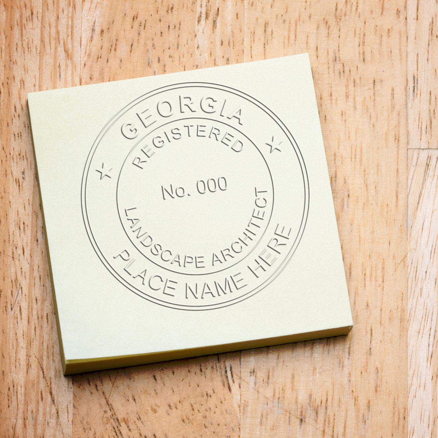 Landscape Architect Black Gift Seal Embosser creating a detailed embossed seal on a yellow sticky note, displaying GEORGIA REGISTERED LANDSCAPE ARCHITECT.