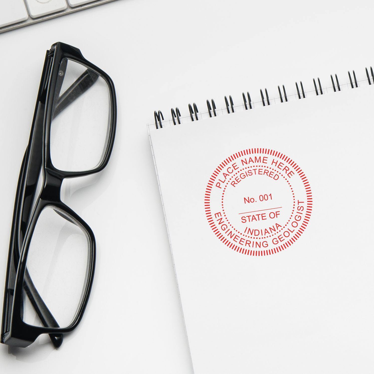 Engineering Geologist eSeal Electronic Image Stamp of Seal in red on a white notepad, next to black glasses and a keyboard.