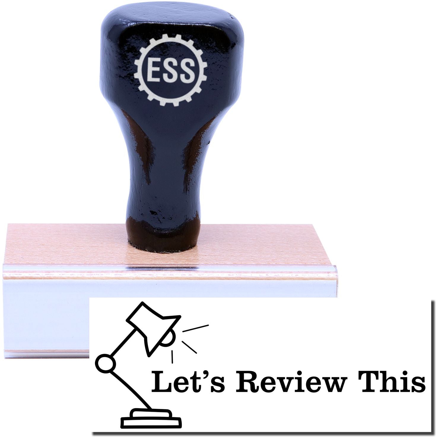 A stock office rubber stamp with a stamped image showing how the text Let's Review This in a large bold font with the image of a lamp is displayed after stamping.