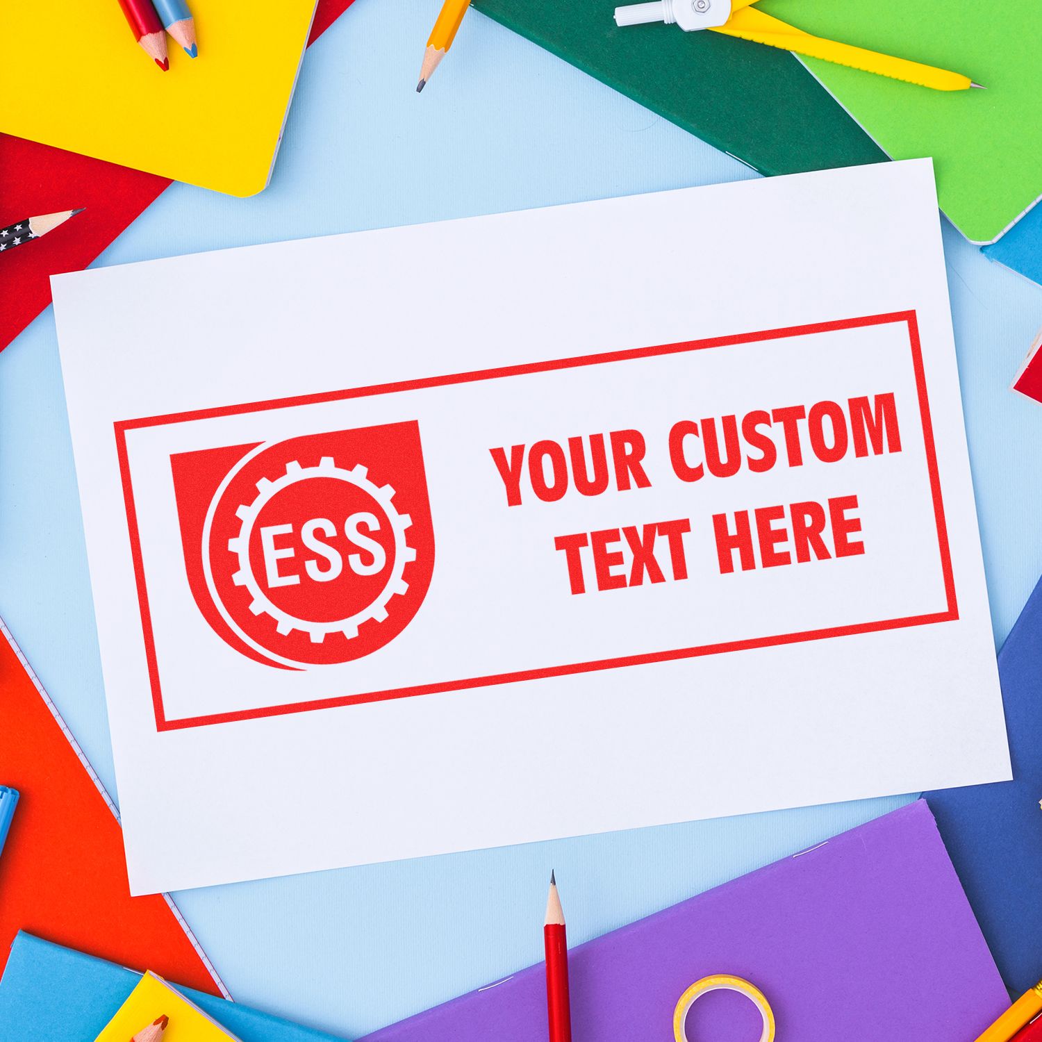 Custom Rubber Stamp Size 1 x 2 with red ink imprinting ESS Your Custom Text Here on white paper, surrounded by colorful stationery.