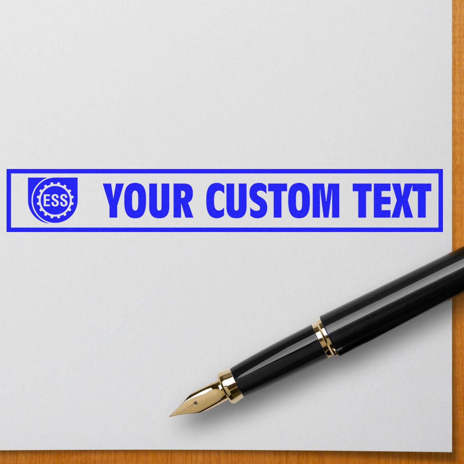 Custom Rubber Stamp Size 1 x 10 in blue ink with YOUR CUSTOM TEXT next to a black fountain pen on a white paper.