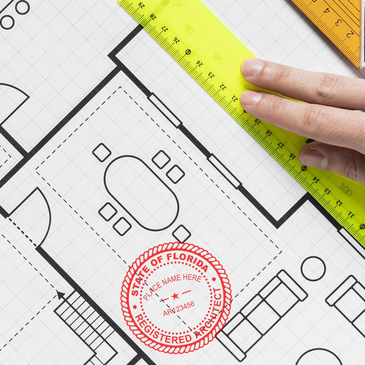 Hand holding a ruler over a blueprint with a red Self Inking Florida Architect Stamp marked on the paper.