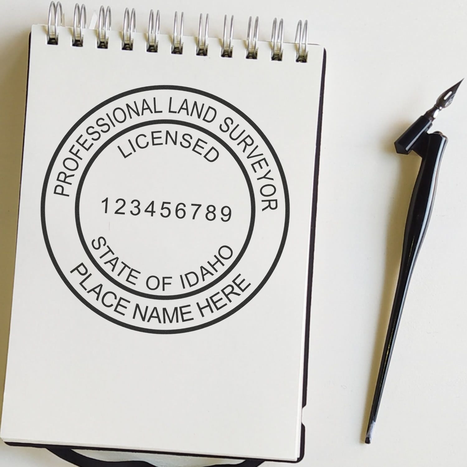 Notepad displaying the Digital Idaho Land Surveyor Stamp, Electronic Seal for Idaho Land Surveyor, with a pen beside it.