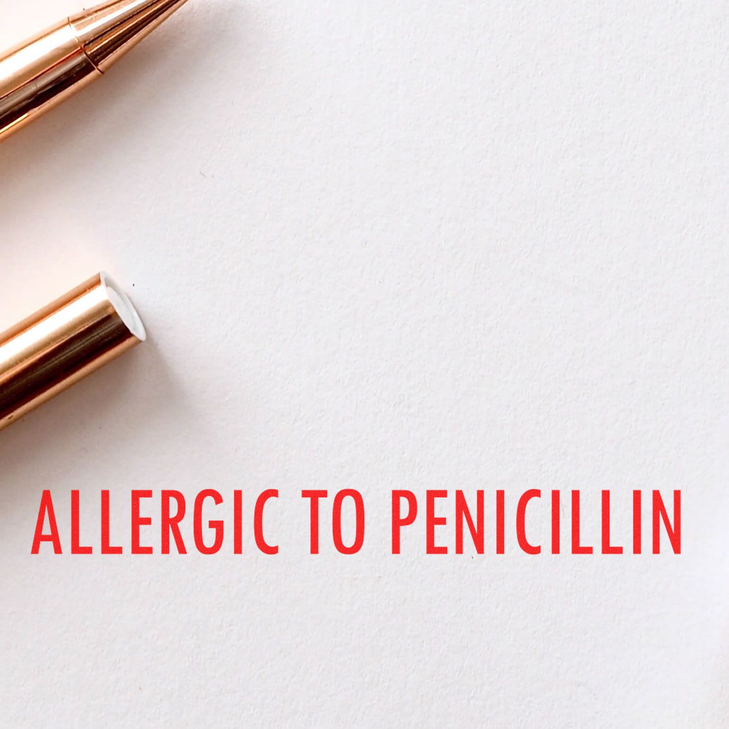 Large Allergic To Penicillin Rubber Stamp in use, displaying bold red text ALLERGIC TO PENICILLIN on white paper with a pen nearby.