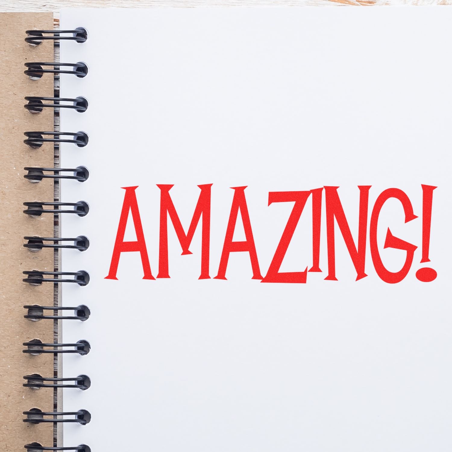 A notebook with a spiral binding and the word AMAZING! stamped in red using the Large Amazing Rubber Stamp.